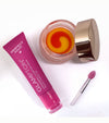 Open strawberry lip treatment jar with a pink and yellow swirl, shown with a pink ‘Perfect Pout’ Glampton tube and a small lip applicator on a white background.