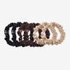 Set of black, brown, and cream scrunchies on a white background