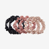 Set of black and pink and cream scrunchies on a white background
