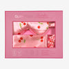 Glampton satin sleep set in cherry print, packaged in a pink gift box showing the satin pillowcase, satin eye mask, and matching scrunchie.