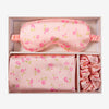 Glampton satin sleep set in floral vintage print displayed inside the open soft pink box, including satin pillowcase, eye mask, and matching scrunchies.