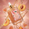 Glampton Sweet Peach Body Oil bottle with peach slices and a pink label on a pink background